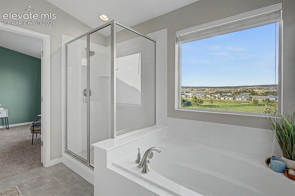 Image 27 of 44: Spacious bathroom featuring a built-in soaking tub, a glass-enclosed shower