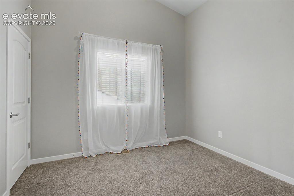 Image 28 of 44: Room featuring neutral wall paint, gray carpet, a white paneled door, and a