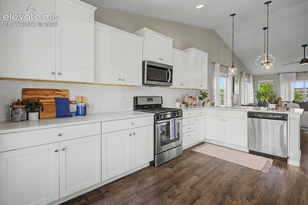 Image 3 of 44: Modern kitchen featuring white shaker cabinetry, stainless steel appliances