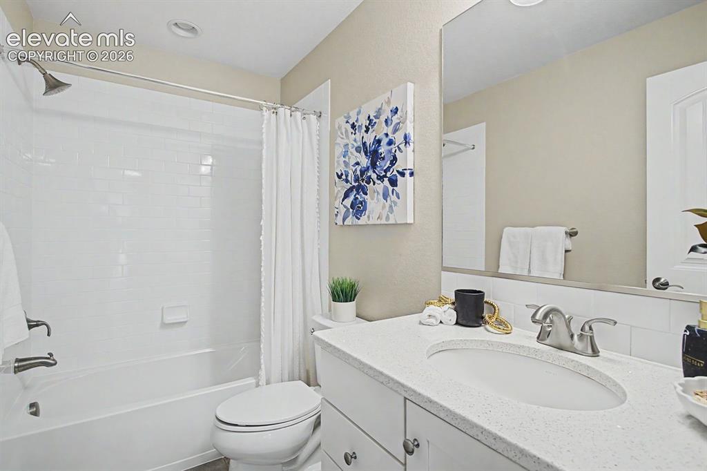 Image 30 of 44: Bathroom featuring a white subway tile tub surround, recessed lighting, and