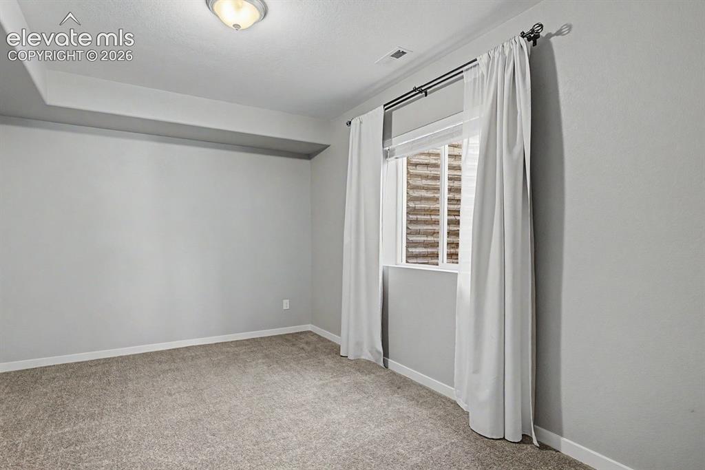 Image 35 of 44: Carpeted room featuring light gray walls, a single window with white blinds