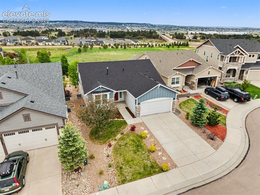 Image 40 of 44: Single-story residence featuring a blue siding facade, stone accents, and a