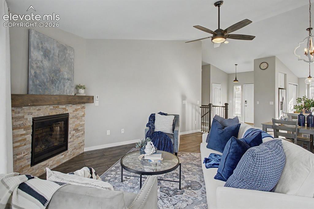 Image 8 of 44: Living area featuring a stone-faced fireplace with a wood mantel, wood-fini
