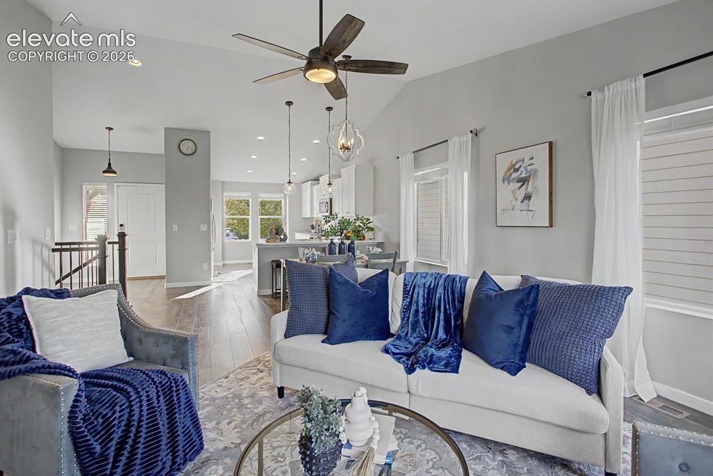 Image 9 of 44: Vaulted ceiling living area featuring a ceiling fan, recessed lighting, woo