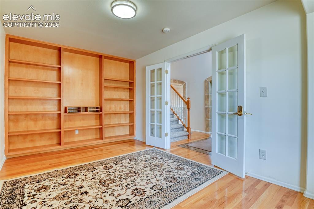 Image 12 of 50: Room with French door and built in shelving