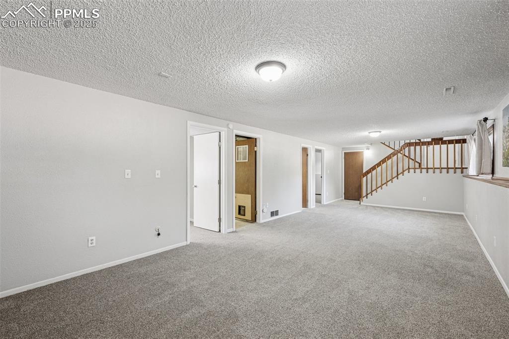 Image 26 of 44: Lower level family room looking towards bedroom, bathroom and laundry room
