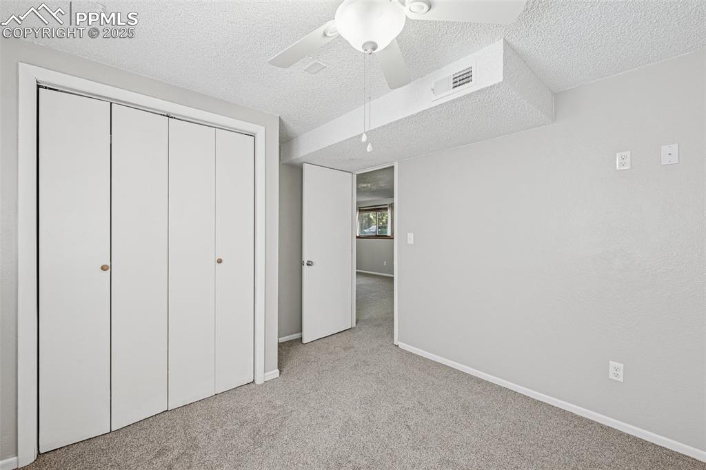 Image 32 of 44: second lower level bedroom, closet built ins, garden level window with good