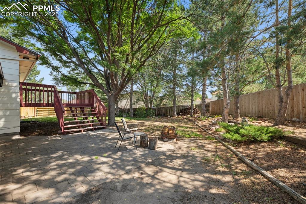Image 36 of 44: Paver area for entertainment area or fire pit use. Large established trees