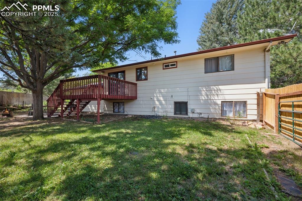 Image 40 of 44: Rear view of home and yard. Lower level bedroom and laundry room windows