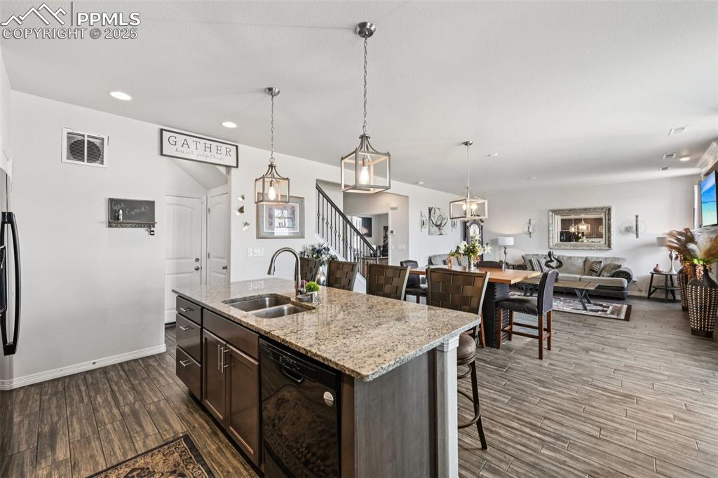 Image 16 of 44: Kitchen featuring black dishwasher, dark wood-type flooring, recessed light