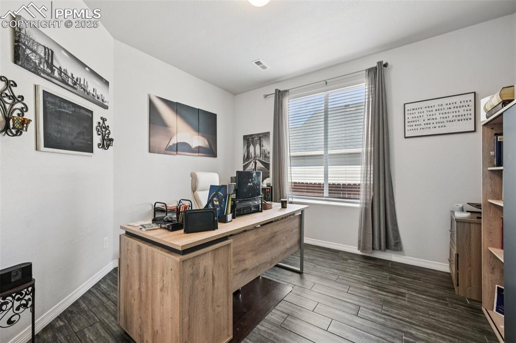 Image 18 of 44: Home office with dark wood-style floors