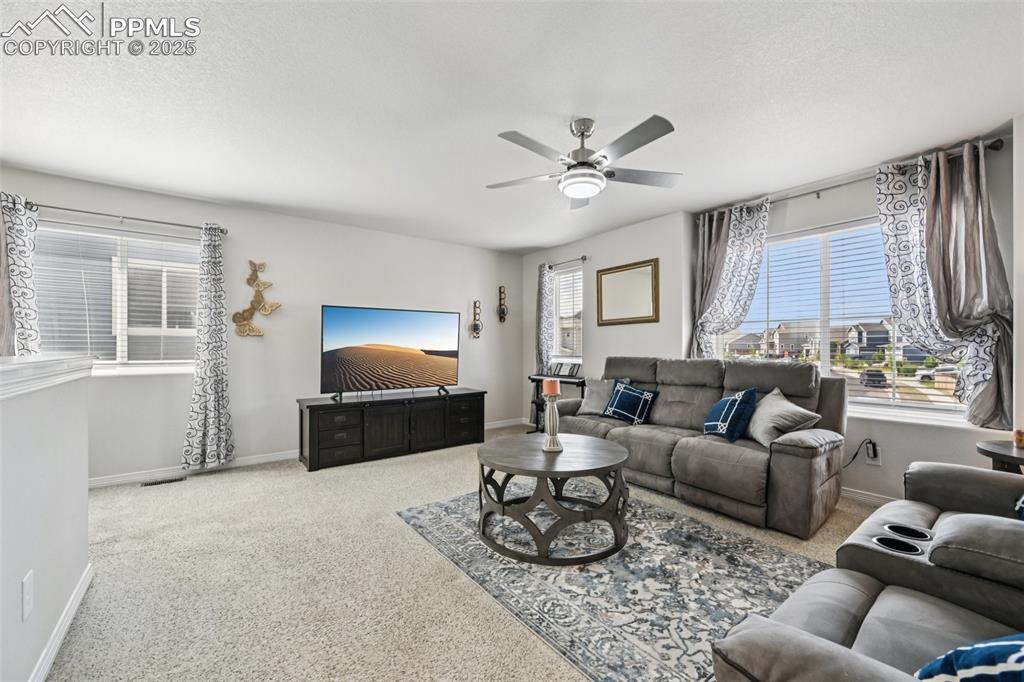 Image 23 of 44: Carpeted living area featuring ceiling fan and baseboards