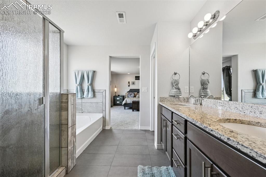 Image 29 of 44: Bathroom with ensuite bathroom, tile patterned flooring, double vanity, a g