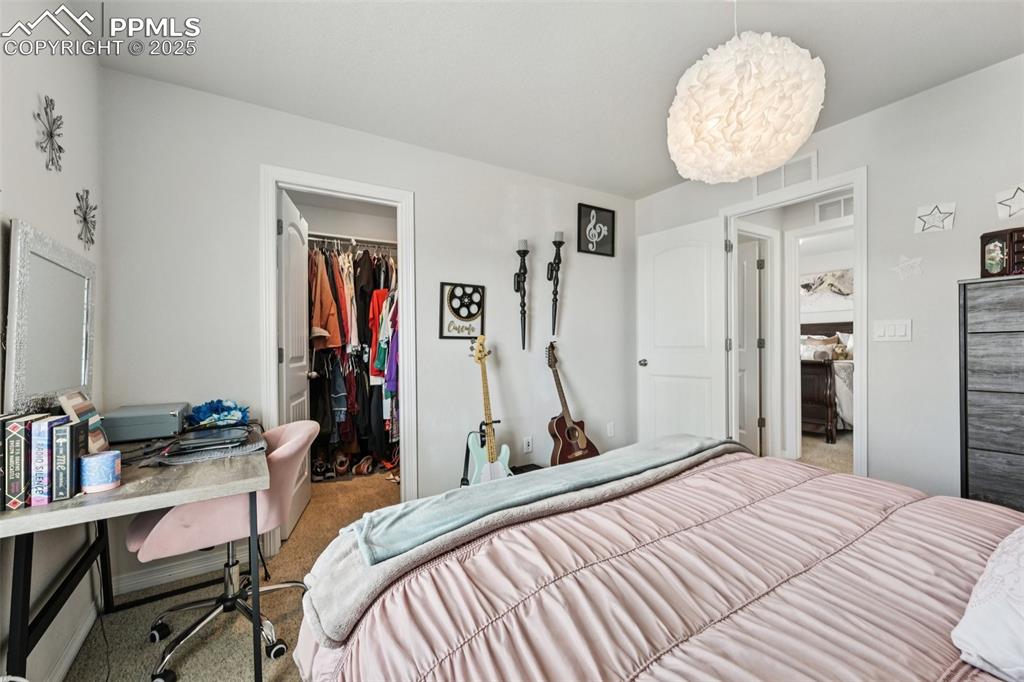 Image 33 of 44: Bedroom featuring carpet, a spacious closet, a desk, and a chandelier