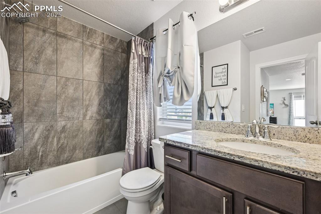 Image 34 of 44: Bathroom with shower / bath combination with curtain, vanity, plenty of nat