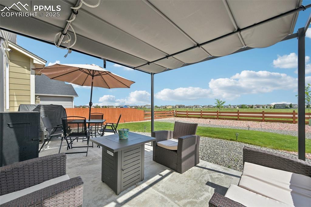 Image 36 of 44: Fenced backyard with outdoor dining area, a view of countryside, a patio, a