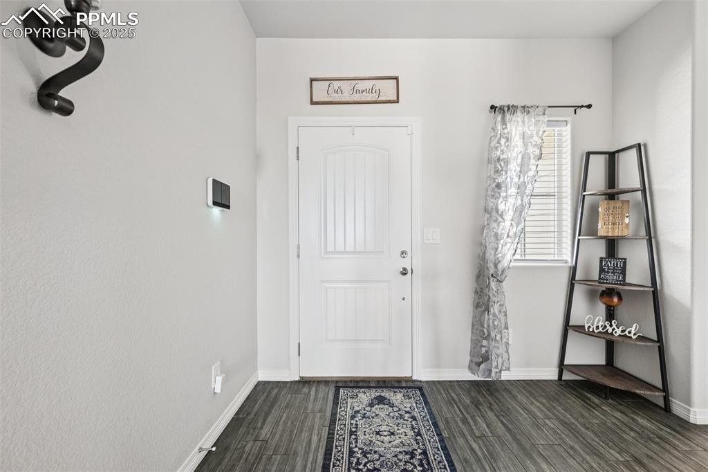 Image 6 of 44: Entrance foyer featuring dark wood finished floors and baseboards
