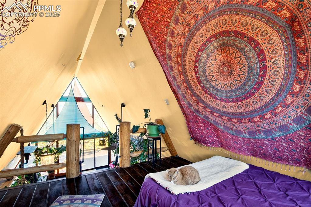 Image 17 of 42: Bedroom featuring wood finished floors and vaulted ceiling