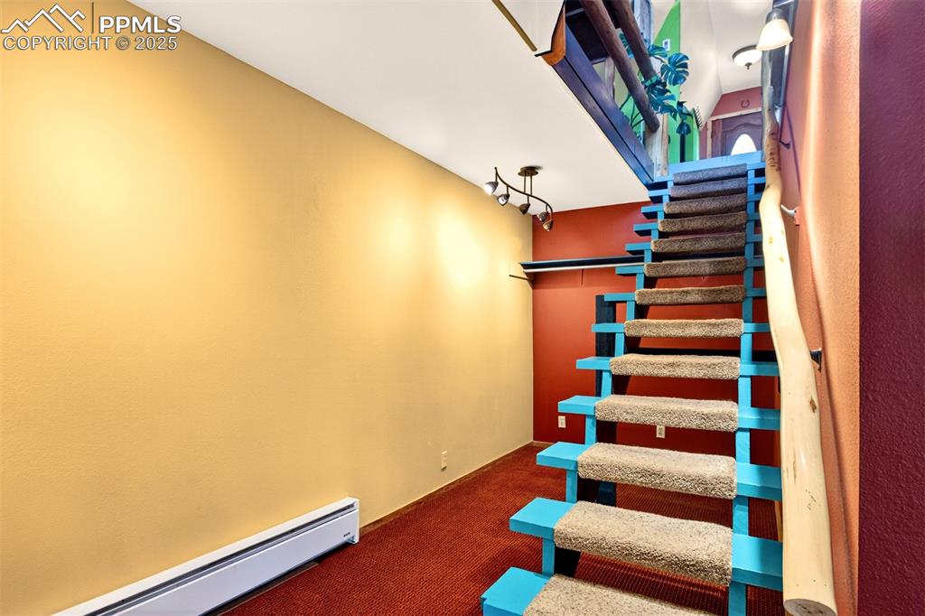 Image 19 of 42: Stairway featuring baseboard heating and carpet