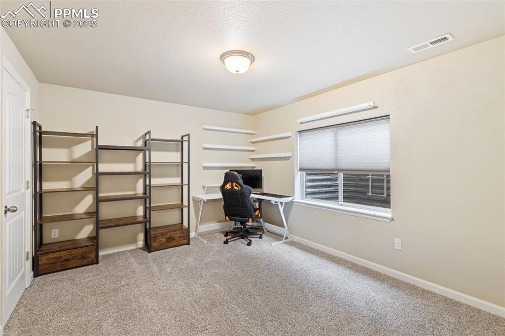 Image 14 of 33: Office area featuring light colored carpet and a textured ceiling