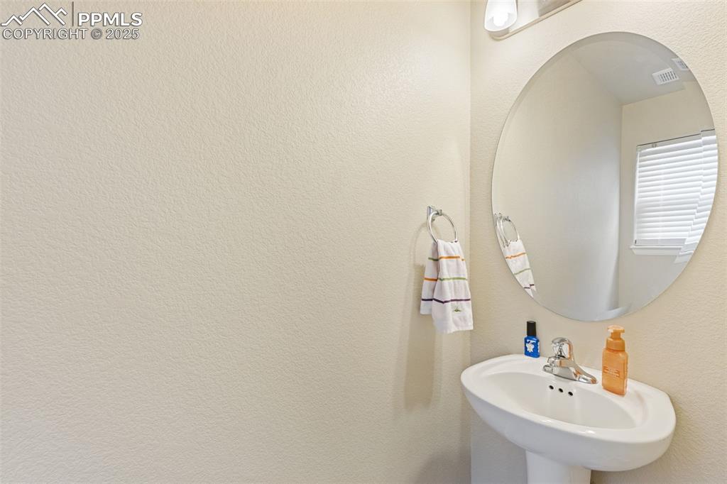 Image 20 of 33: Bathroom featuring a textured wall and a sink