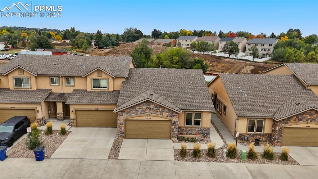 Image 22 of 33: View of front of property featuring stucco siding, stone siding, concrete d