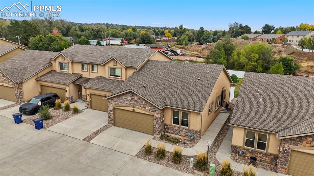 Image 24 of 33: View of front of house with stucco siding, stone siding, and concrete drive