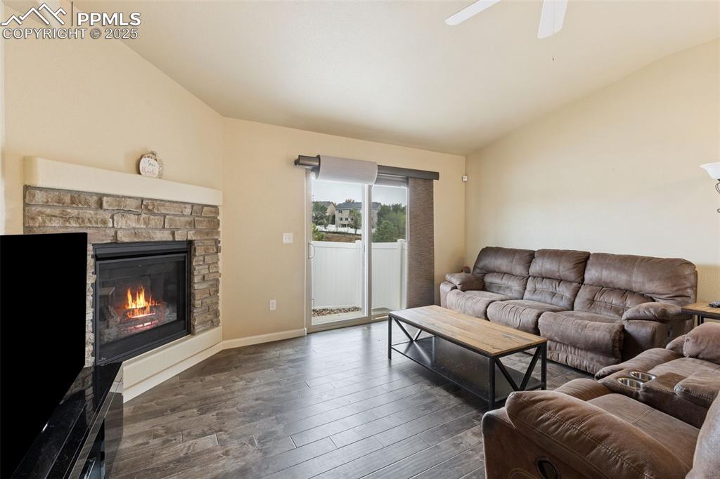 Image 3 of 33: Living area with hardwood / wood-style floors, lofted ceiling, and a firepl
