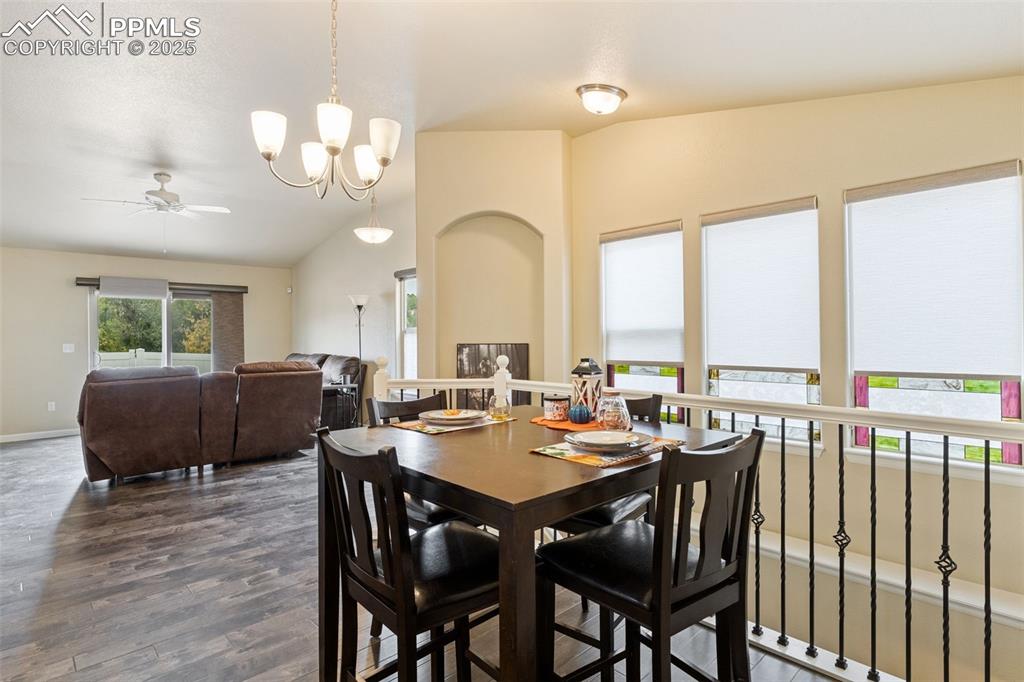 Image 7 of 33: Dining area featuring lofted ceiling, ceiling fan, dark wood-style floors,