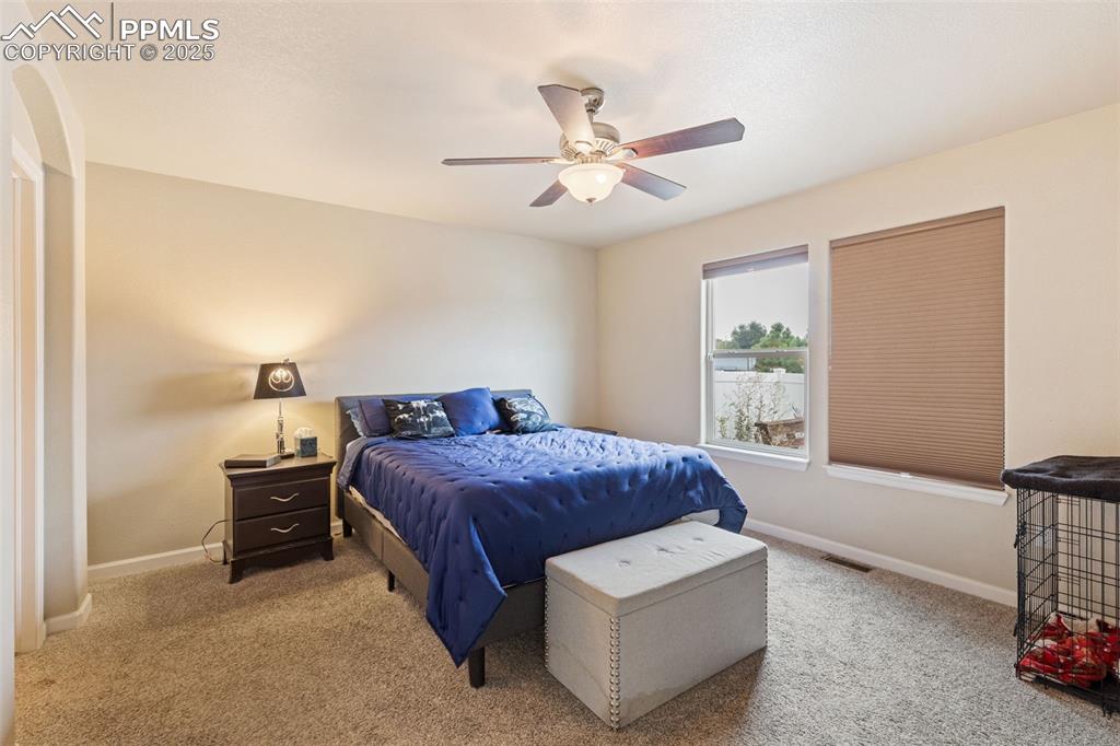 Image 8 of 33: Carpeted bedroom with baseboards and a ceiling fan