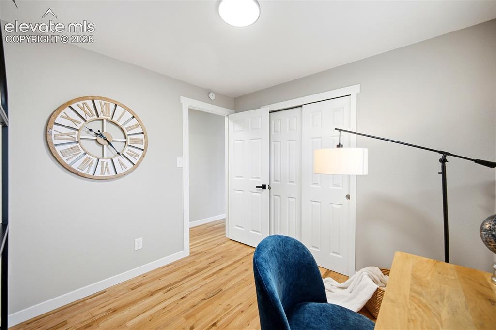 Image 10 of 26: Light wood-finish flooring, white trim, and light gray wall paint