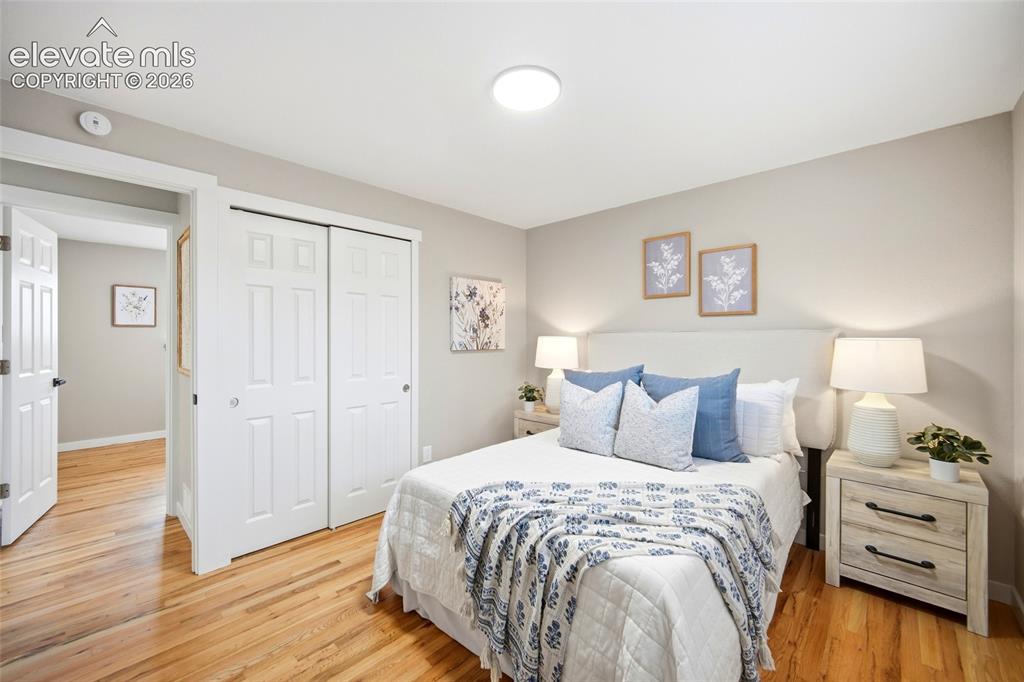 Image 12 of 26: Hardwood flooring, painted walls, white trim, flat panel ceiling light, and