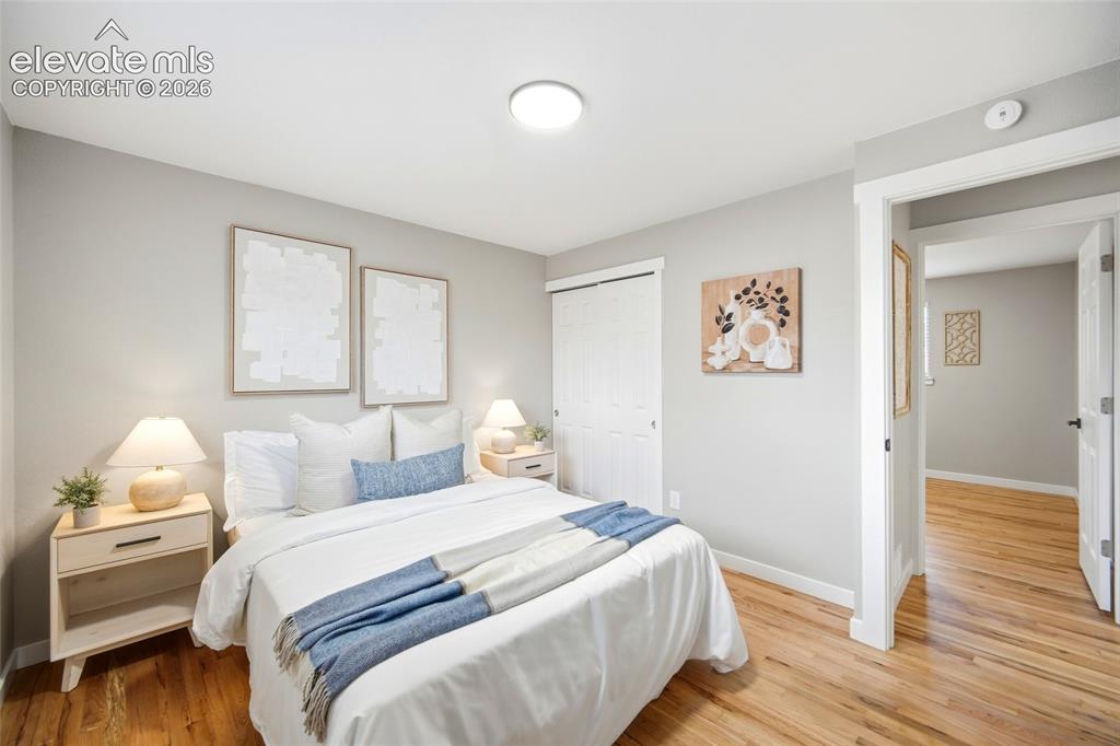 Image 14 of 26: Hardwood flooring, light gray wall finishes, white trim, and a built-in clo