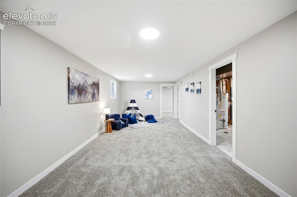 Image 16 of 26: Expansive carpeted area with neutral wall finishes and recessed lighting