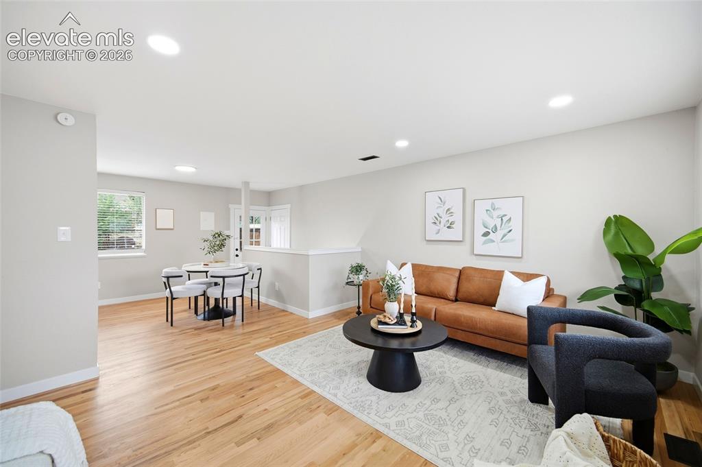 Image 2 of 26: Open-concept common area featuring wood-finish flooring, recessed lighting,