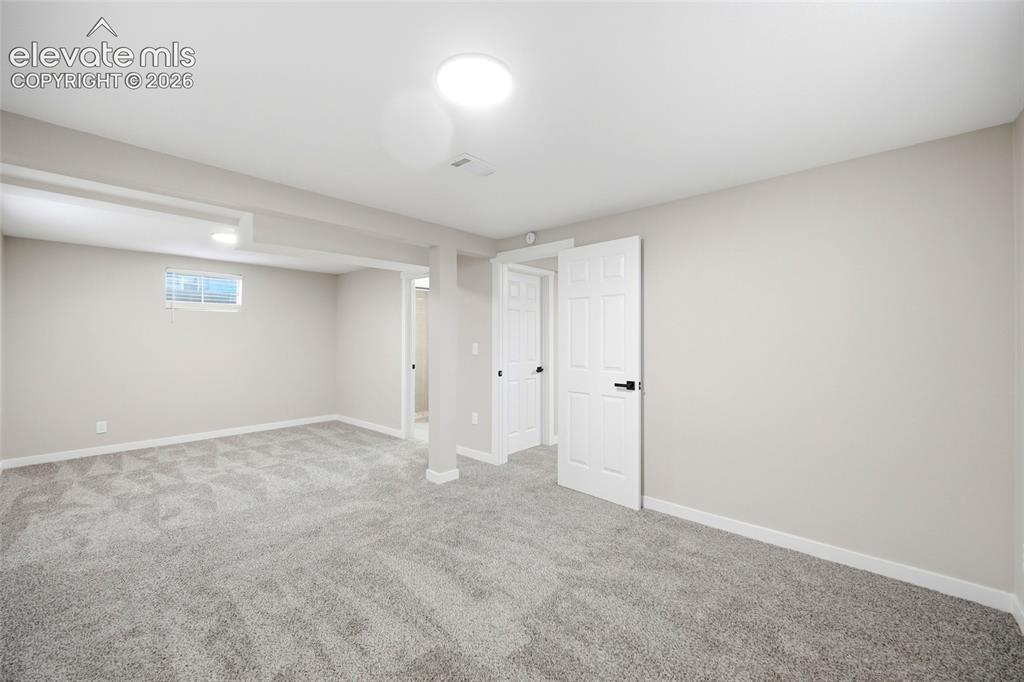 Image 20 of 26: Expansive carpeted area with neutral wall finishes, recessed lighting, and