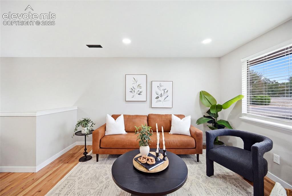 Image 3 of 26: Recessed lighting, wood-finish flooring, white window blinds, and light-ton