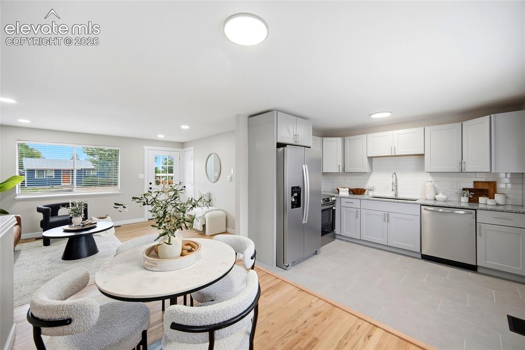 Image 5 of 26: Bright kitchen with stainless steel appliances and subway tile backsplash