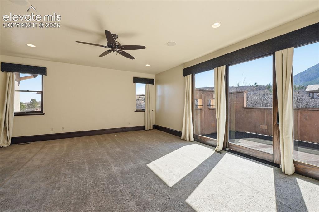 Image 19 of 49: Primary bedroom walks out to private patio.