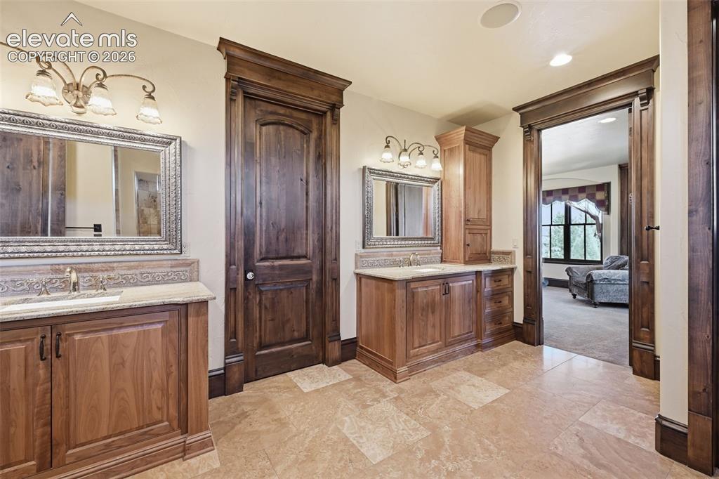 Image 22 of 49: Separate, primary vanities. Extensive walk in closet!