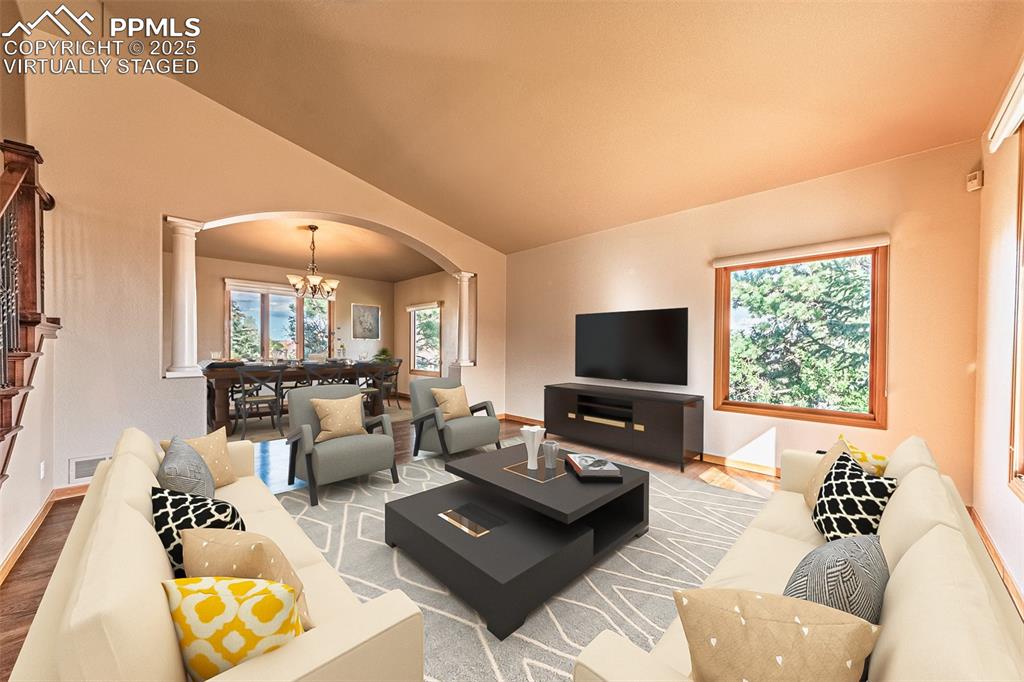 Image 10 of 45: Virtually Staged
Living area featuring arched walkways, a chandelier, wood