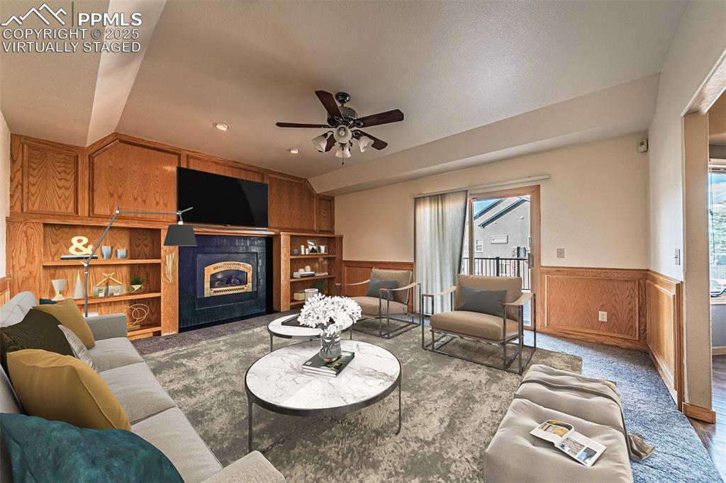 Image 24 of 45: Virtually Staged
Family room with wainscoting, a fireplace, wood walls, ca