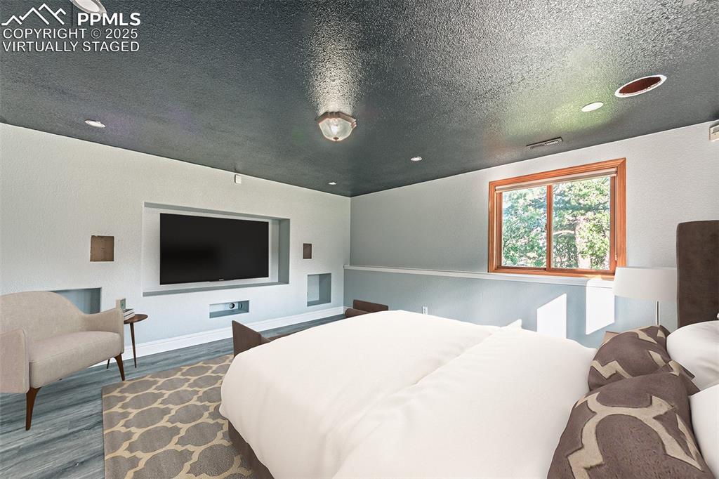 Image 36 of 45: Virtually Staged
Bedroom with wood finished floors, a textured ceiling, an