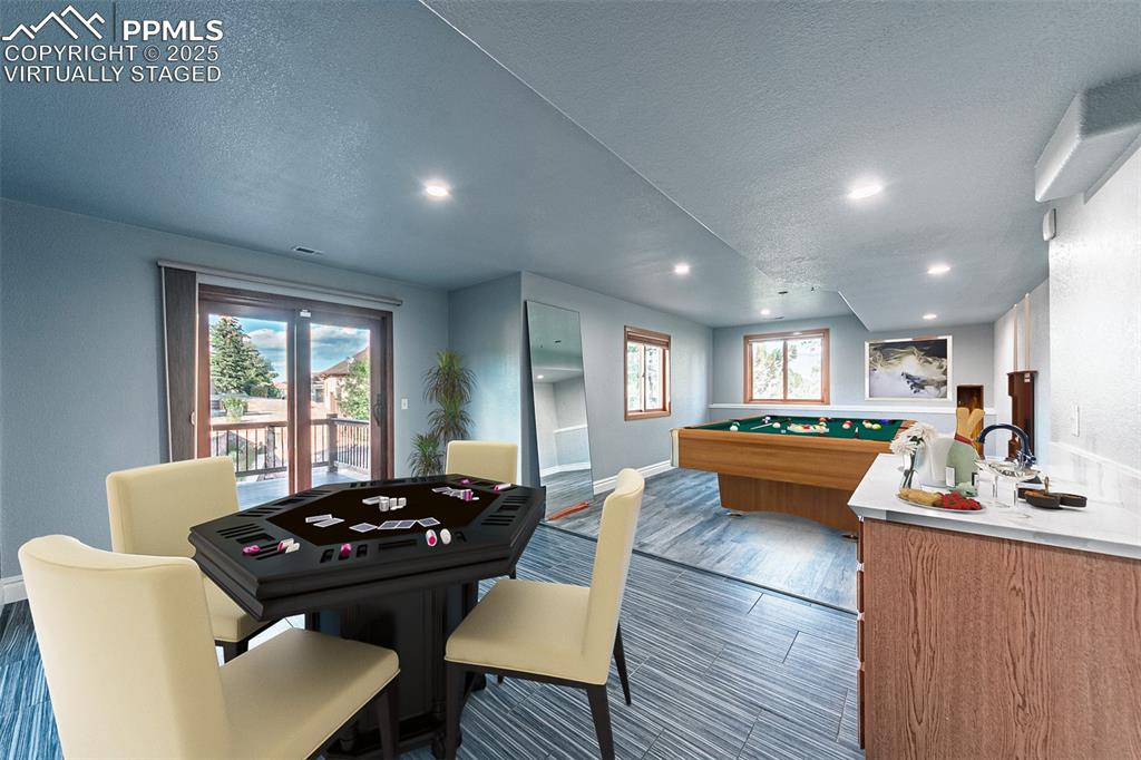 Image 40 of 45: Virtually Staged
Game room featuring dark wood-type flooring, a textured c