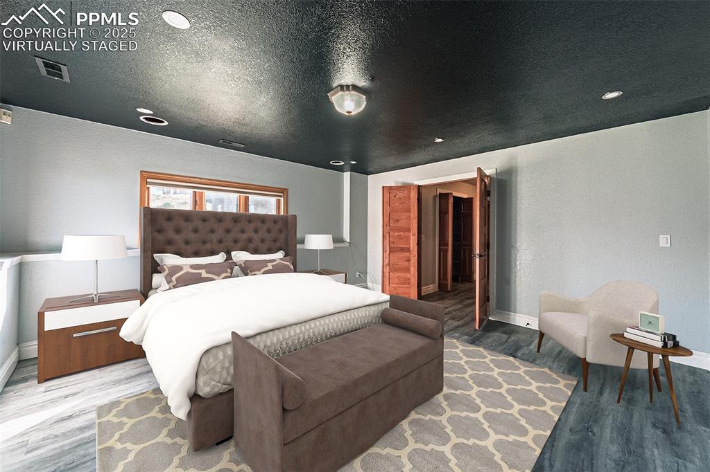Image 42 of 45: Virtually Staged
Bedroom featuring wood finished floors, a textured wall, 