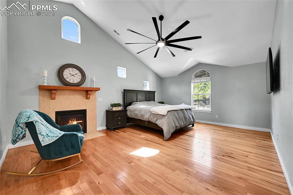 Image 25 of 50: Primary bedroom featuring sitting area with fireplace