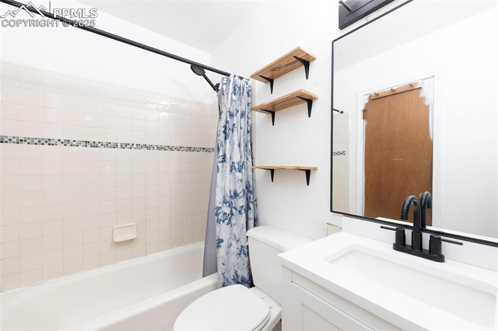 Image 17 of 25: Bathroom with vanity and shower / bath combination with curtain