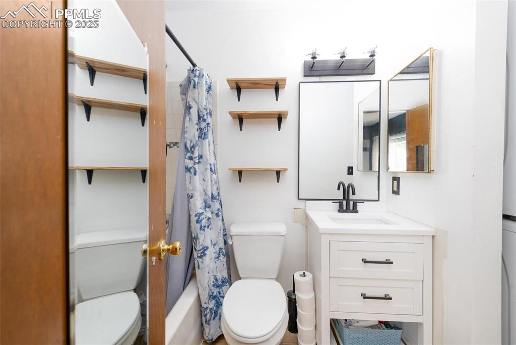 Image 18 of 25: Full bath with vanity and shower / tub combo with curtain