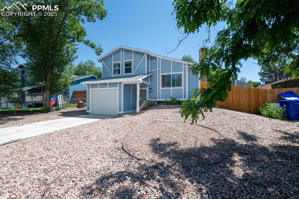 Image 23 of 25: View of front facade with driveway, a garage, and stucco siding