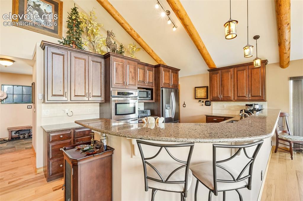 Image 17 of 50: Open concept kitchen with quartz counter tops, matching stainless appliance